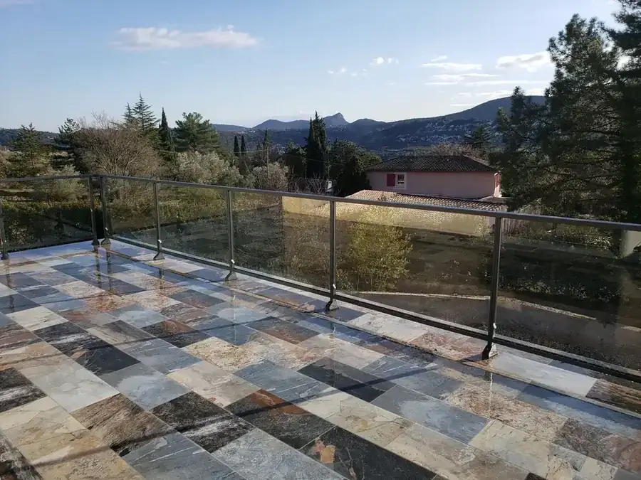 Garde-corps en verre et métal sur une terrasse face à la vallée