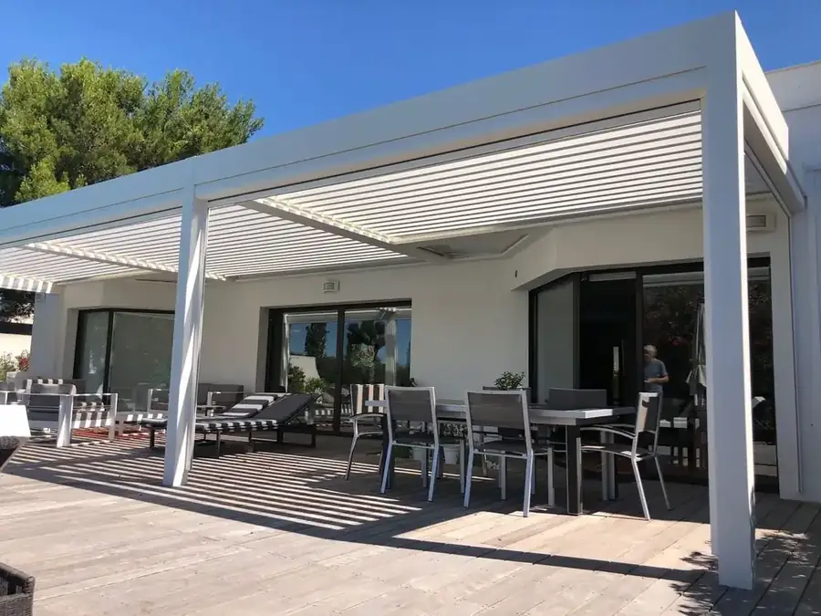 Grande pergola blanche à lames sur une terrasse en bois, maison contemporaine
