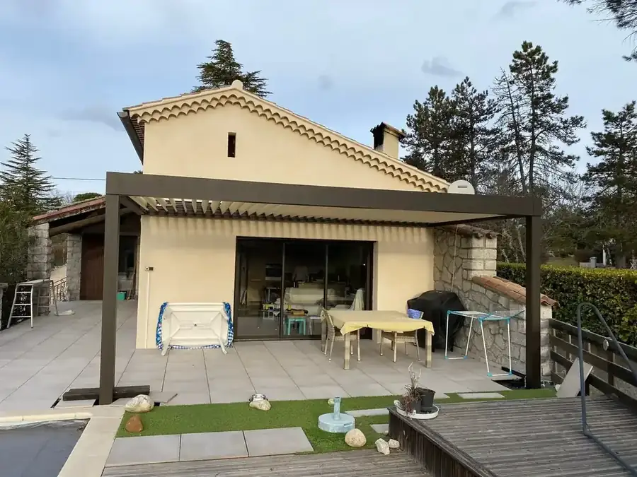 Pergola anthracite sur la terrasse d'une maison crépie de style provençal