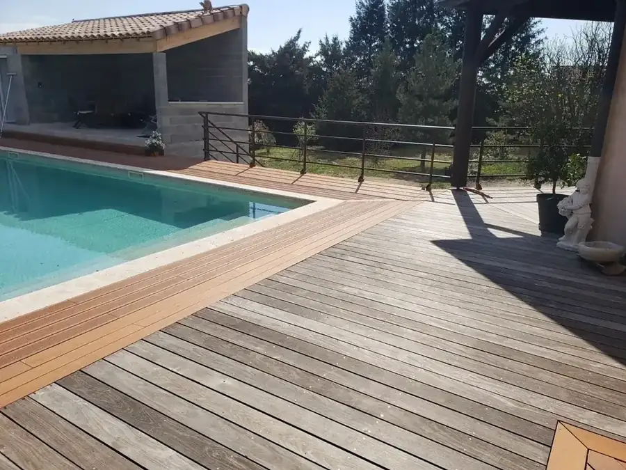 Terrasse en bois autour d'une piscine avec garde-corps métal